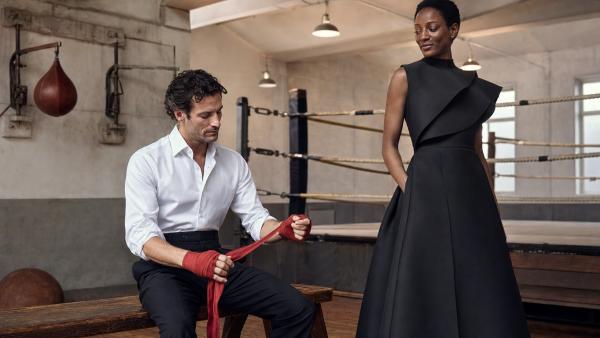 Man unwrapping boxing wraps beside an elegantly dressed woman