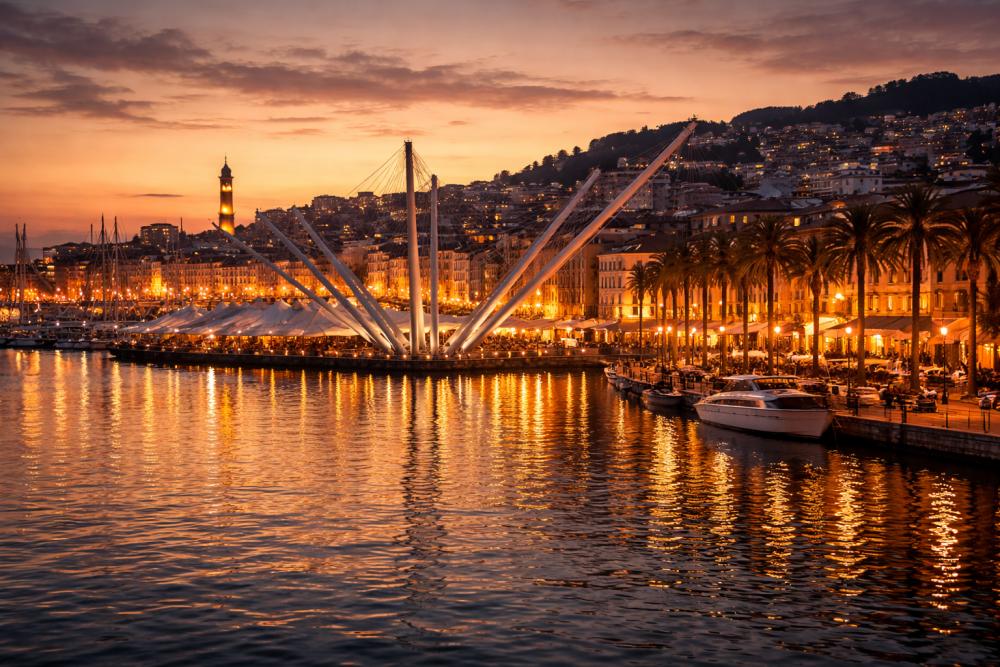 Tramonto sul Porto Antico di Genova con luci calde e atmosfera romantica