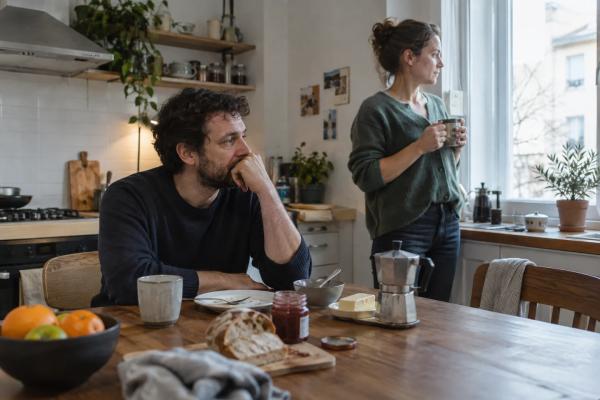 Due partner condividono la cucina al mattino mentre la routine rivela una distanza emotiva